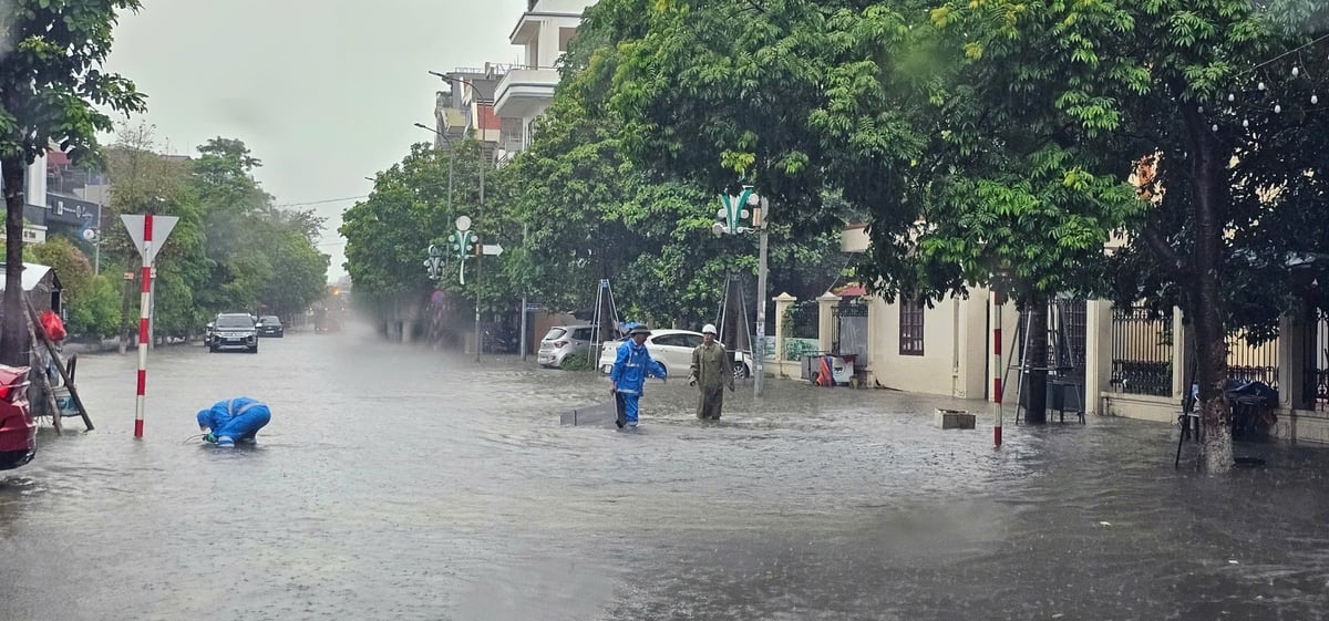 Công nhân Công ty CP Quản lý công trình đô thị Bắc Giang đội mưa đi khơi thông các cửa thu nước của nắp cống. Ảnh: Phạm Minh. Công nhân Công ty CP Quản lý công trình đô thị Bắc Giang đội mưa đi khơi thông các cửa thu nước của nắp cống. Ảnh: Phạm Minh.