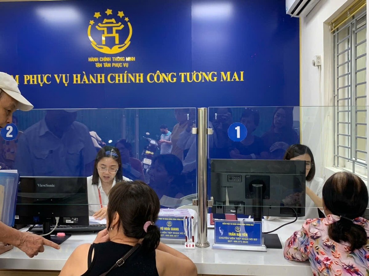 Mỗi bàn tiếp đón đều gắn biển tên, chức vụ và số điện thoại cán bộ để người dân tiện liên hệ, giúp giải quyết thủ tục nhanh gọn. Ảnh: Lan Chi.