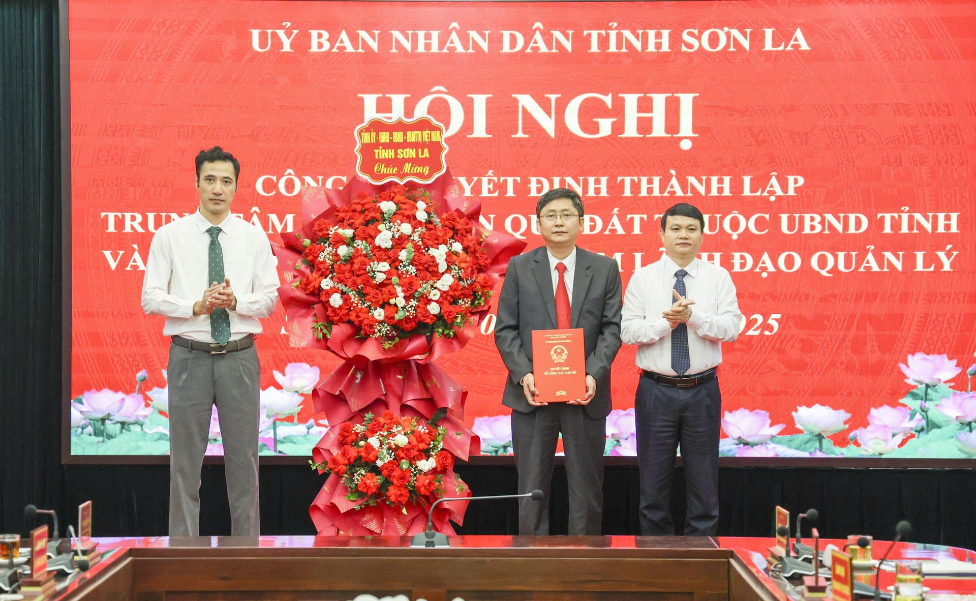 Phó Chủ tịch UBND tỉnh Sơn La Đặng Ngọc Hậu trao Quyết định thành lập Trung tâm phát triển quỹ đất tỉnh và tặng hoa chúc mừng Tập thể lãnh đạo Trung tâm. Ảnh: Nguyễn Nga.
