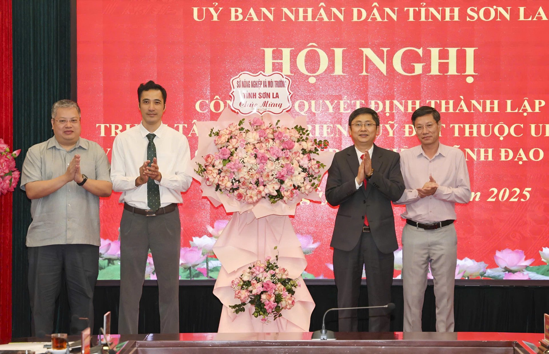 Lãnh đạo Sở Nông nghiệp và Môi trường tặng hoa chúc mừng Trung tâm phát triển quỹ đất tỉnh. Ảnh: Nguyễn Nga.