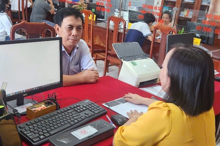 Cán bộ Trung tâm Phục vụ hành chính công xã Vị Thanh 1 hướng dẫn người dân giải quyết thủ tục hành chính. Ảnh: Kim Anh.