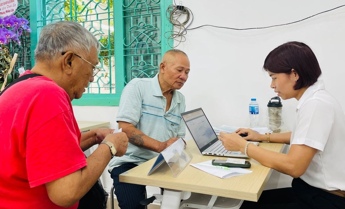 Cán bộ phường Xuân Hòa hướng dẫn người dân làm thủ tục giấy tờ. Ảnh: Đình Du.