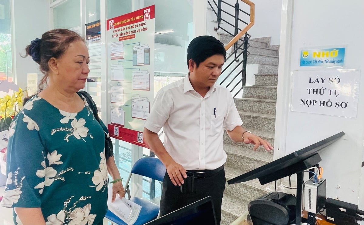 Ông Nguyễn Minh Thiện - Phó Chủ tịch UBND phường Tân Hưng hướng dẫn người dân bấm số thứ tự. Ảnh: Đình Du.
