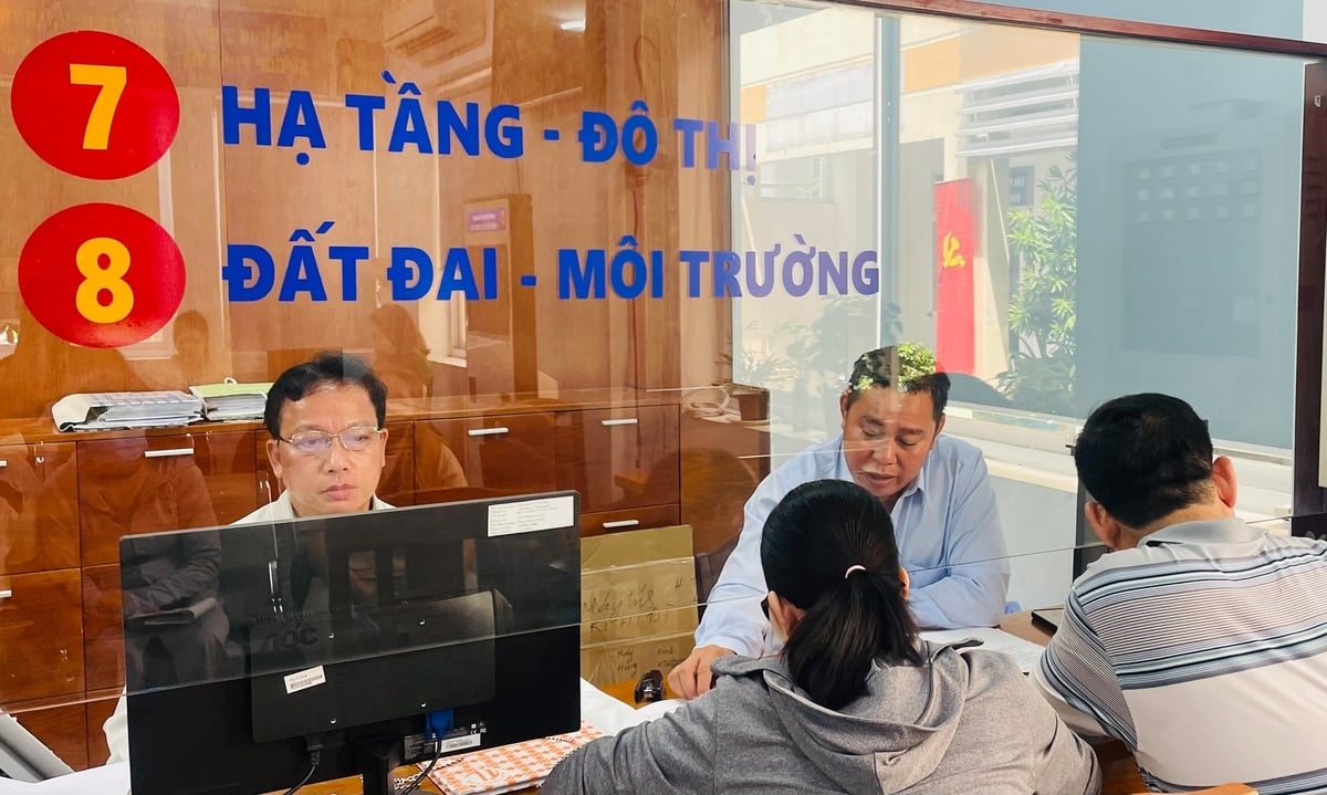 Cán bộ bộ phận nông nghiệp - môi trường hỗ trợ người dân đăng ký làm thủ tục đất đai. Ảnh: Đình Du. 