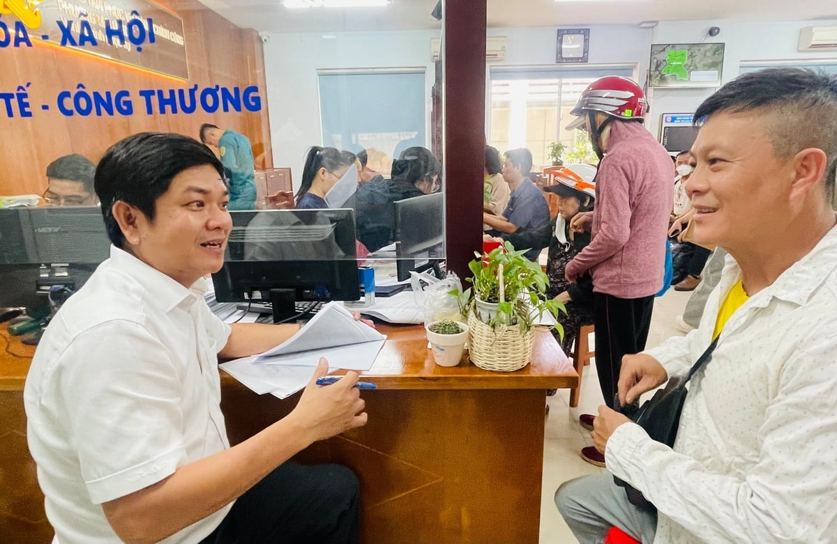 Lãnh đạo phường Tân Hưng (bên trái) trực tiếp ký giấy tờ, hồ sơ tại bàn tiếp công dân. Ông Hòa (bên phải) chia sẻ, anh rất vui khi thủ tục làm hồ sơ được giải quyết rất nhanh gọn. Ảnh: Đình Du.  