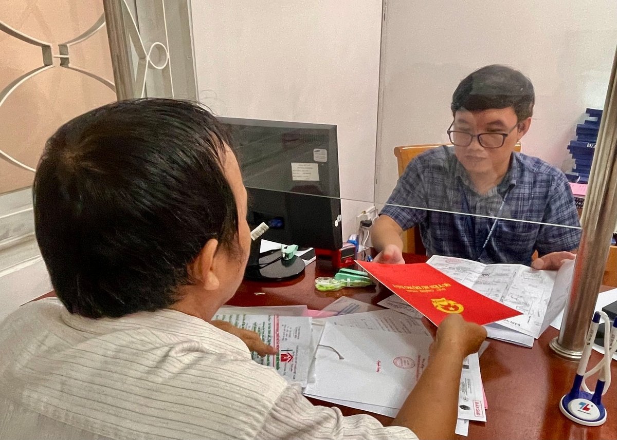Cán bộ phụ trách đất đai phường Sài Gòn hướng dẫn người dân làm thủ tục. Ảnh: Đình Du. 