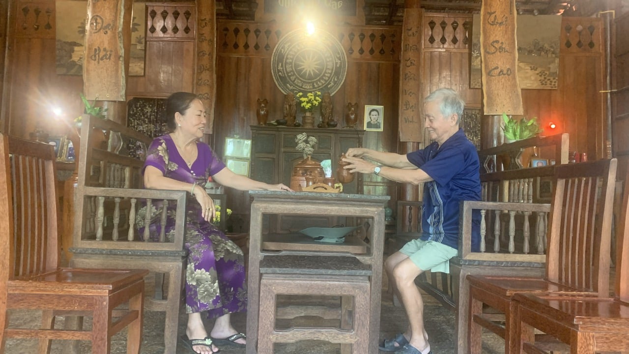 Mrs. Giac and her husband enjoy tea on a long bench set crafted entirely from coconut wood. Photo: Ho Thao.