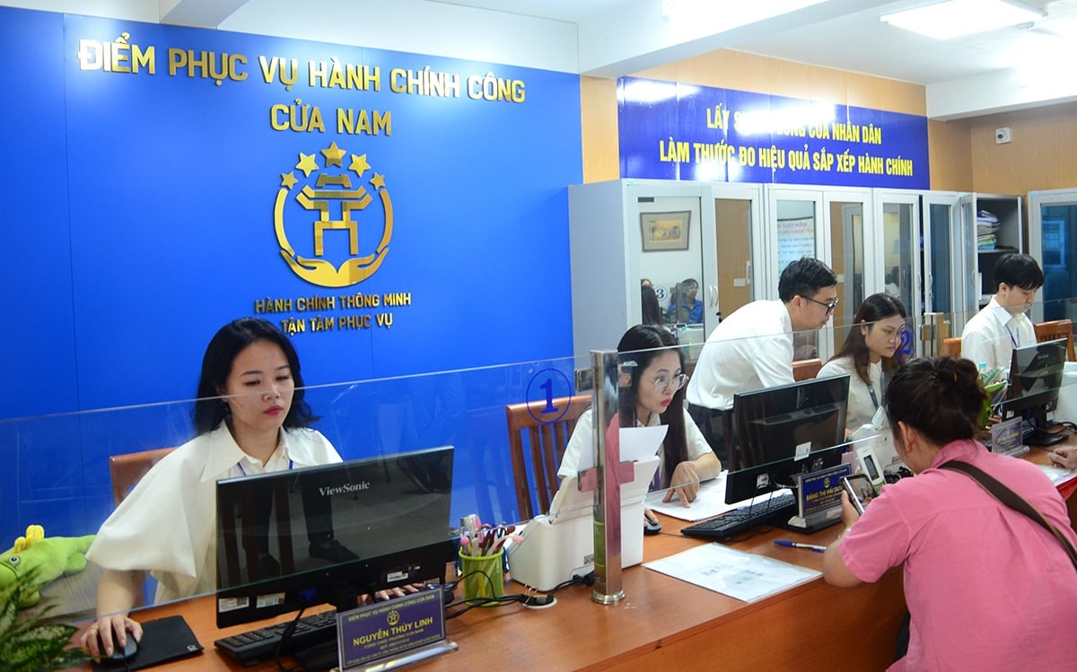 Cán bộ điểm phục vụ hành chính công phường Cửa Nam tiếp đón người dân đến làm thủ tục. Ảnh: Nguyễn Hà.