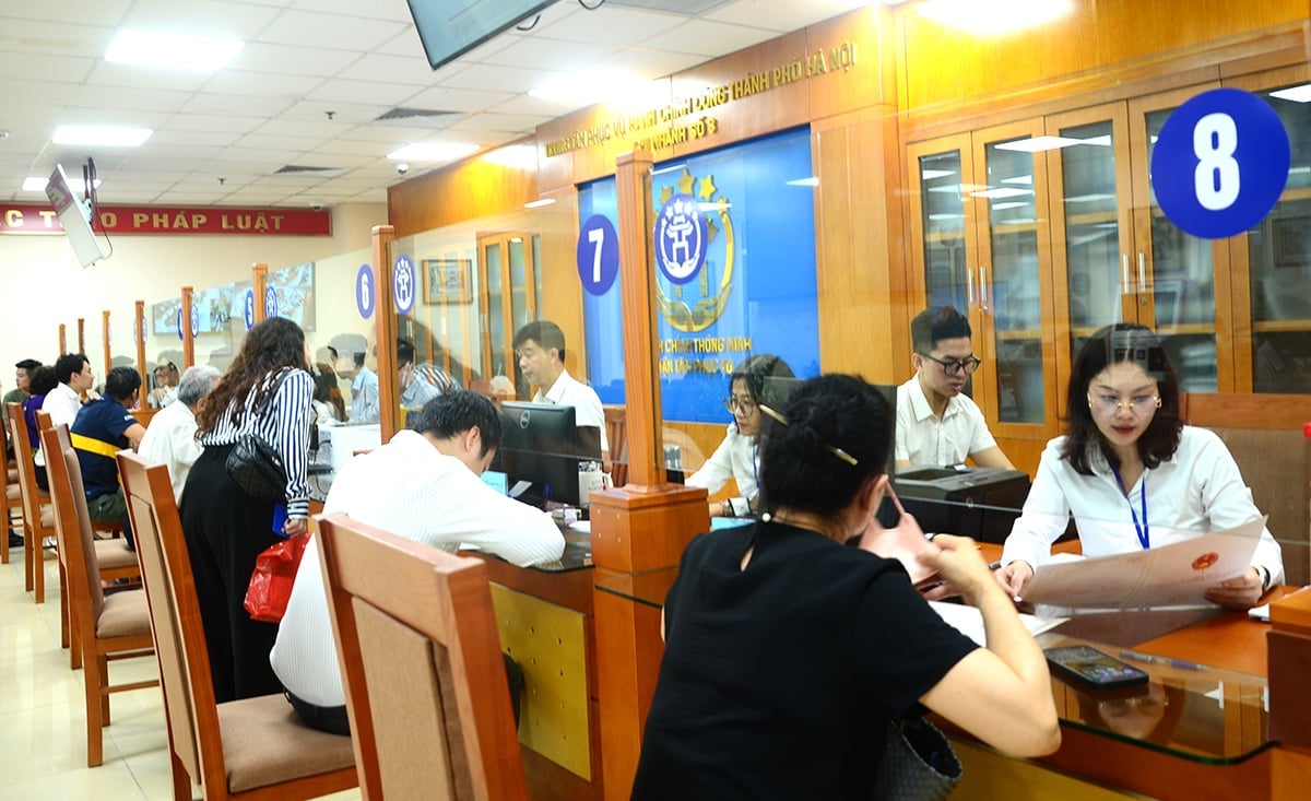 Cán bộ Trung tâm phục vụ hành chính công TP Hà Nội - chi nhánh số 3 hướng dẫn chi tiết người dân về thủ tục đính chính sổ đỏ. Ảnh: Xuân Hà.