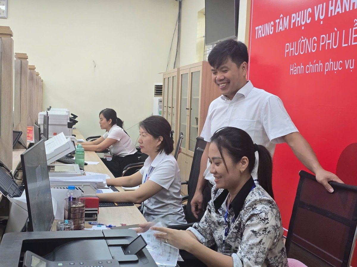 Cán bộ, công chức tại Trung tâm phục vụ hành chính công (TTHCC) cười vui vẻ tiếp nhận công việc khi chính quyền 2 cấp chính thức hoạt động. Ảnh: Đinh Mười.