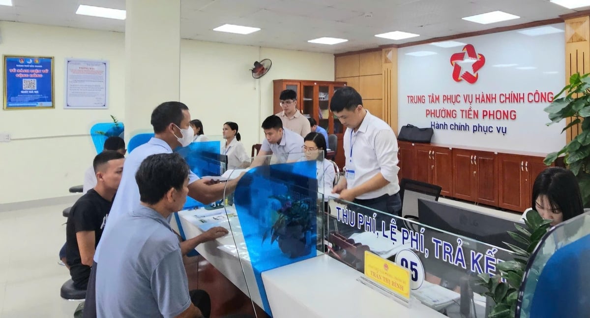 Người dân được cán bộ phường Tiền Phong hướng dẫn rất cụ thể từng việc. Ảnh: Phạm Minh.