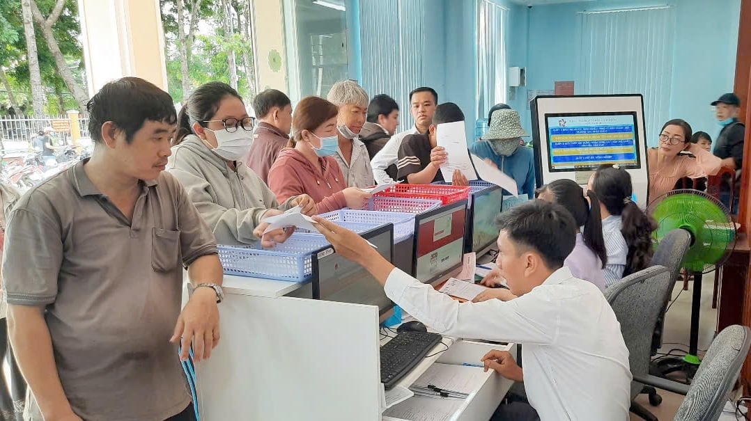 Nhân viên Trung tâm Phục vụ hành chính công xã Cần Giuộc tiếp nhận hồ sơ từ người dân. Ảnh: Thanh Bạch.