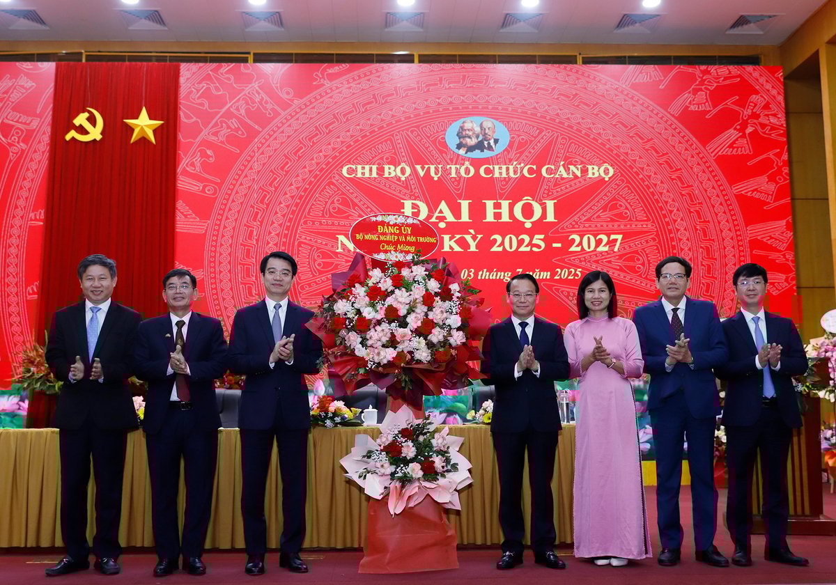 Thay mặt Đảng ủy Bộ, Bộ trưởng Đỗ Đức Duy tặng hoa chúc mừng Đại hội Chi bộ Vụ Tổ chức cán bộ, đồng thời đánh giá cao những thành tựu mà Chi bộ Vụ Tổ chức cán bộ đã đạt được trong nhiệm kỳ vừa qua. Ảnh: Khương Trung.