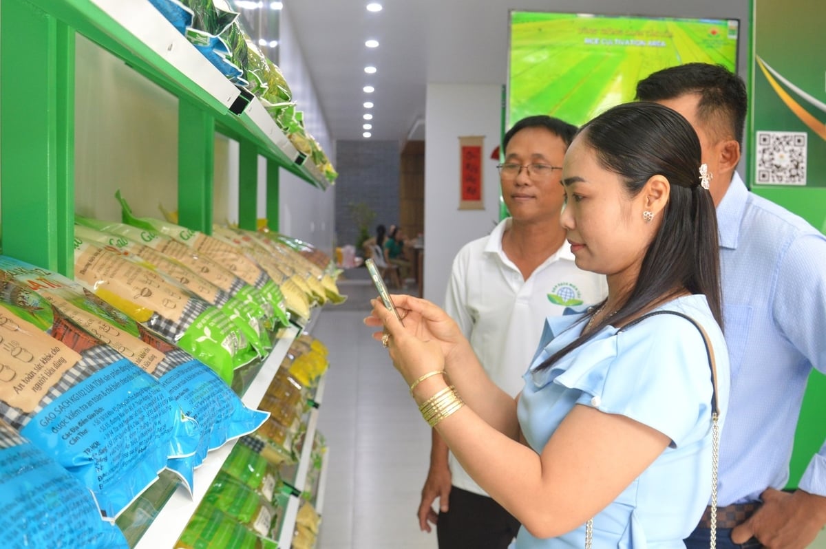 Khách hàng sử dụng điện thoại thông minh quét mã truy xuất nguồn gốc sản phẩm sản phẩm gạo sạch Organic do Công ty TNHH MTV An toàn lương thực sạch Miền Tây sản xuất và phân phối ở cửa hàng vừa khai trương tại phường Rạch Giá. Ảnh: Trung Chánh.