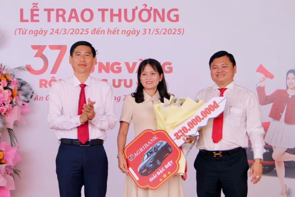 Ông Phan Văn Bá, Phó Trưởng Văn phòng đại diện Agribank khu vực Tây Nam Bộ (bìa trái) và ông Phạm Minh Tấn, Giám đốc Agribank Kiên Giang II (bìa phải) trao giải đặc biệt cho khách hàng may mắn. Ảnh: Minh Khương.