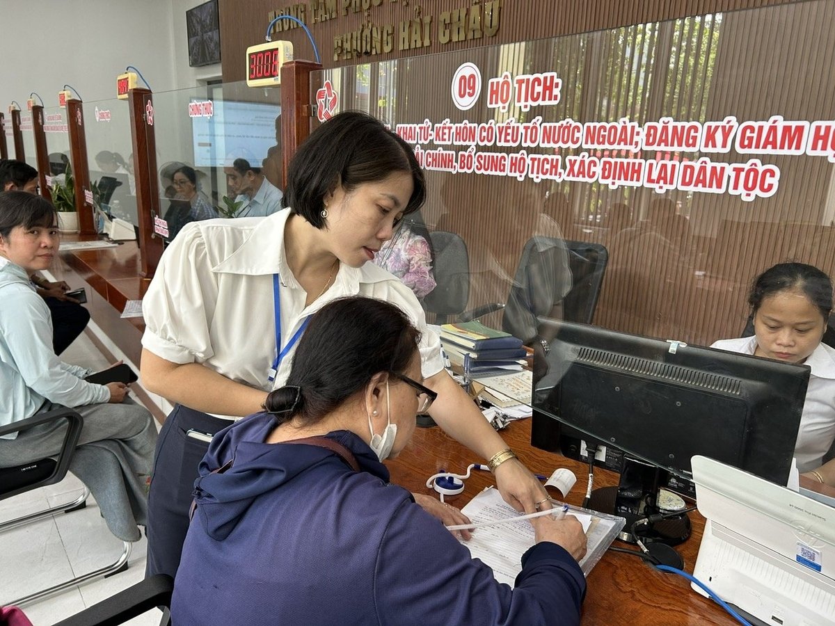Cán bộ Trung tâm phục vụ Hành chính công phường Hải Châu hướng dẫn người dân làm thủ tục đất đai. Ảnh: Lan Anh