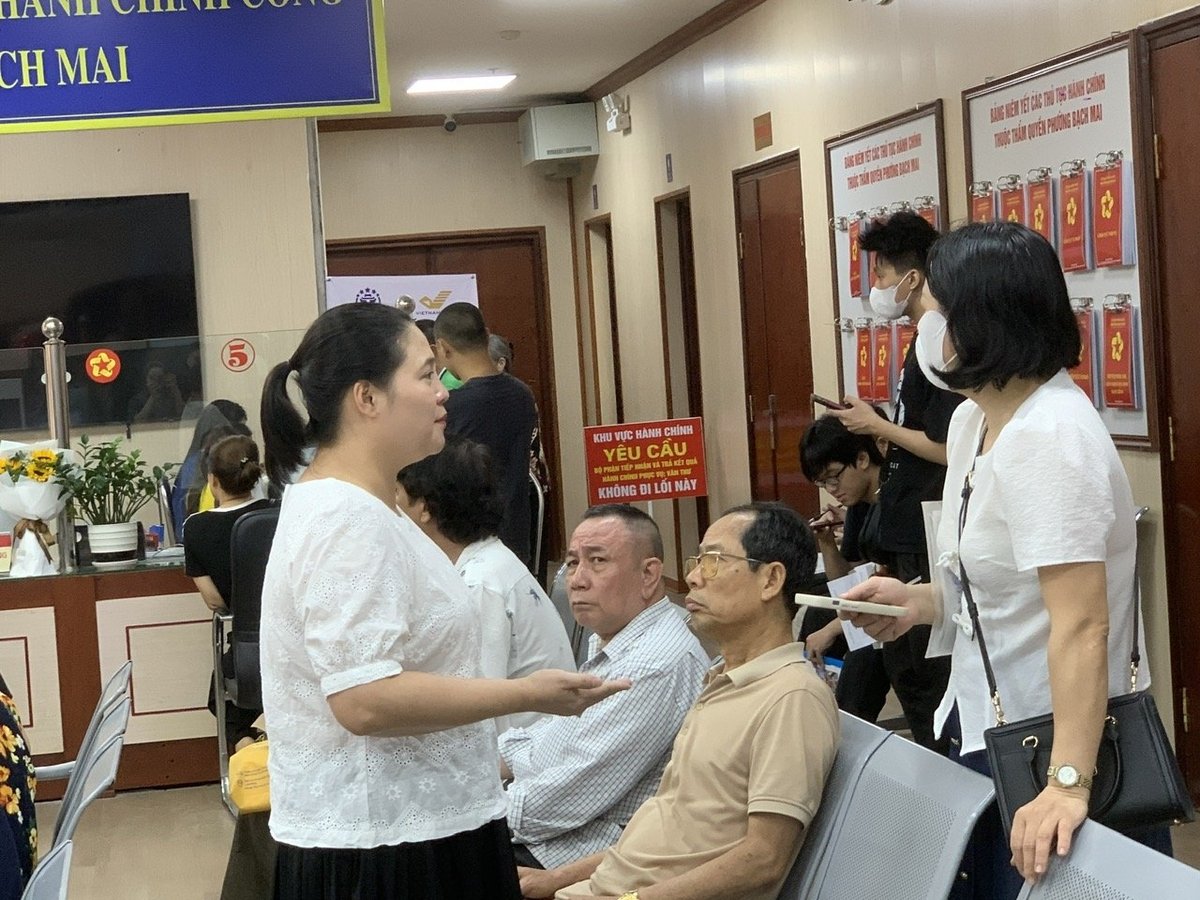 Bà Hoàng Thị Thu Hà (áo trắng bên trái), cán bộ thường trực tại điểm phục vụ hành chính công phường Bạch Mai hướng dẫn người dân đến làm thủ tục đất đai. Ảnh: Mai Đan. Bà Hoàng Thị Thu Hà (áo trắng bên trái), cán bộ thường trực tại điểm phục vụ hành chính công phường Bạch Mai hướng dẫn người dân đến làm thủ tục đất đai. Ảnh: Mai Đan.
