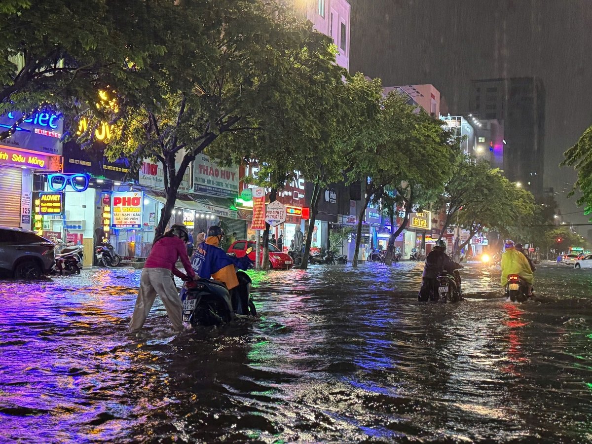 Người dân bì bõm dắt xe qua đoạn đường Lê Duẩn - Ông Ích Khiêm bị ngập. Ảnh: Lan Anh. Người dân bì bõm dắt xe qua đoạn đường Lê Duẩn - Ông Ích Khiêm bị ngập. Ảnh: Lan Anh.