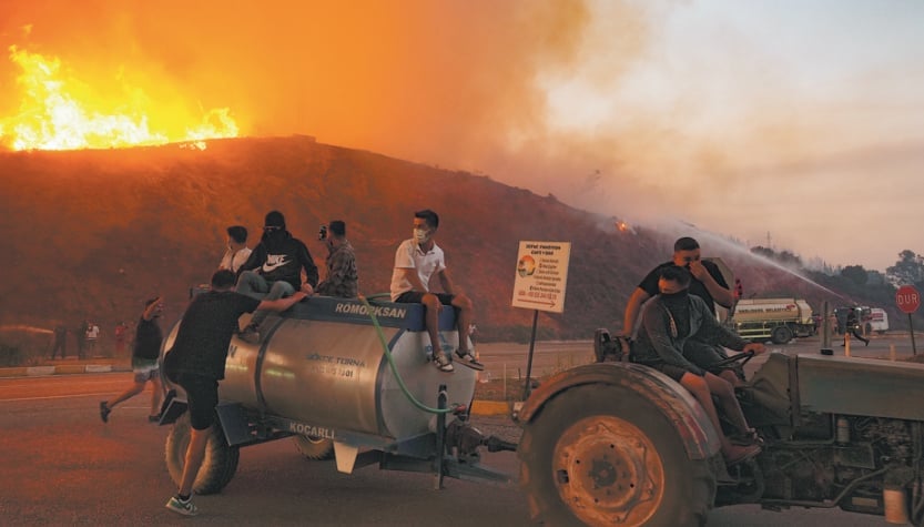 Smoke and flames rise as aerial and ground extinguishing works continue for wildfires in Seferihisar district of Izmir, Turkiye.
