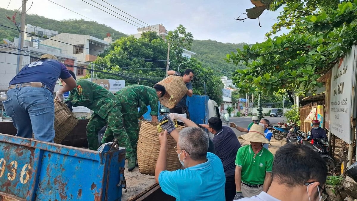 Các lực lượng tập kết rác lên xe đưa đi xử lý. Ảnh: Quang Anh.