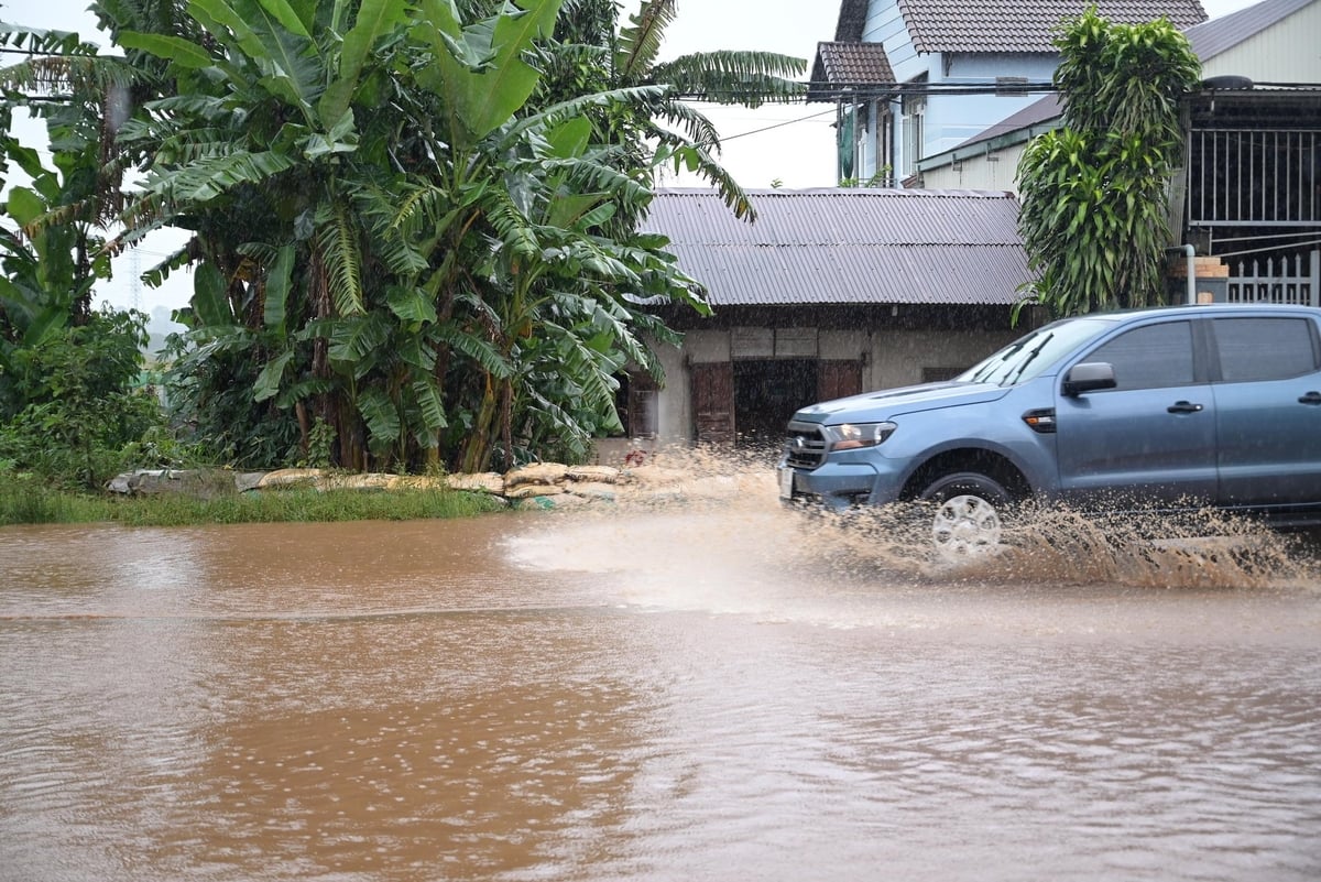 Những ngôi nhà thấp hơn mặt đường dù đã dùng bao xếp thành hàng cao cả mét để ngăn nước nhưng mỗi khi mưa lớn các xe ô tô di chuyển với tốc độ cao thì nước đổ vào nhà làm ngập cả sân và sàn nhà. Ảnh: Phạm Hoài.