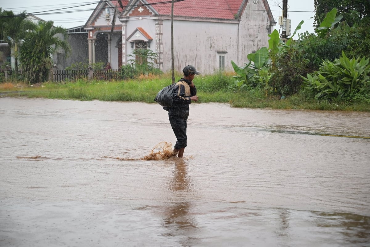 Nước ngập cao nên việc di chuyển qua lại của người dân hai bên đường cũng tiềm ẩn nhiều nguy cơ mất an toàn. Ảnh: Phạm Hoài.