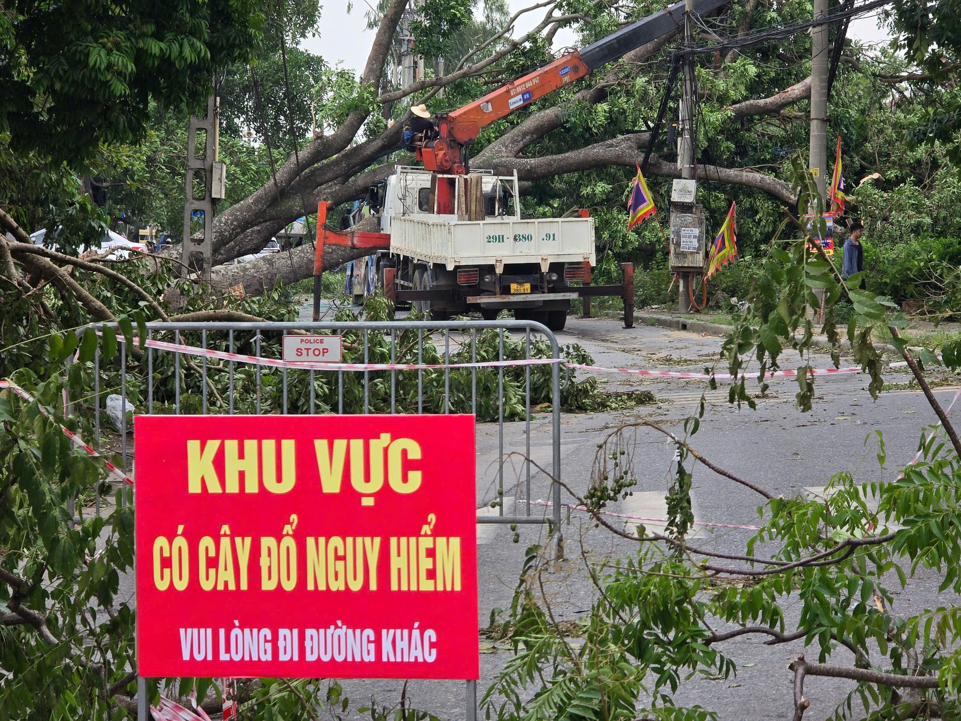 Lực lượng chức năng dựng rào chắn, đặt biển cảnh báo tại khu vực cây đổ để đảm bảo an toàn. Ảnh: Thiên Trường.