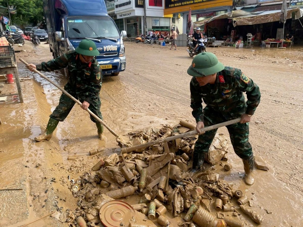 Các chiến sỹ quân đội dọn dẹp trên Quốc lộ 7A khắc phục hậu quả lũ lụt. Ảnh: Đình Tuân.