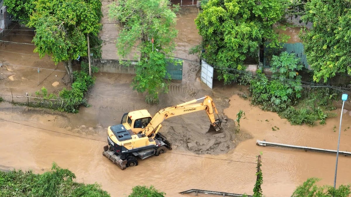 Từ sáng sớm 24/7, tại xã Con Cuông nước rút đến đâu máy xúc xử lý bùn đất đến đó.Ảnh: Đình Tiệp.