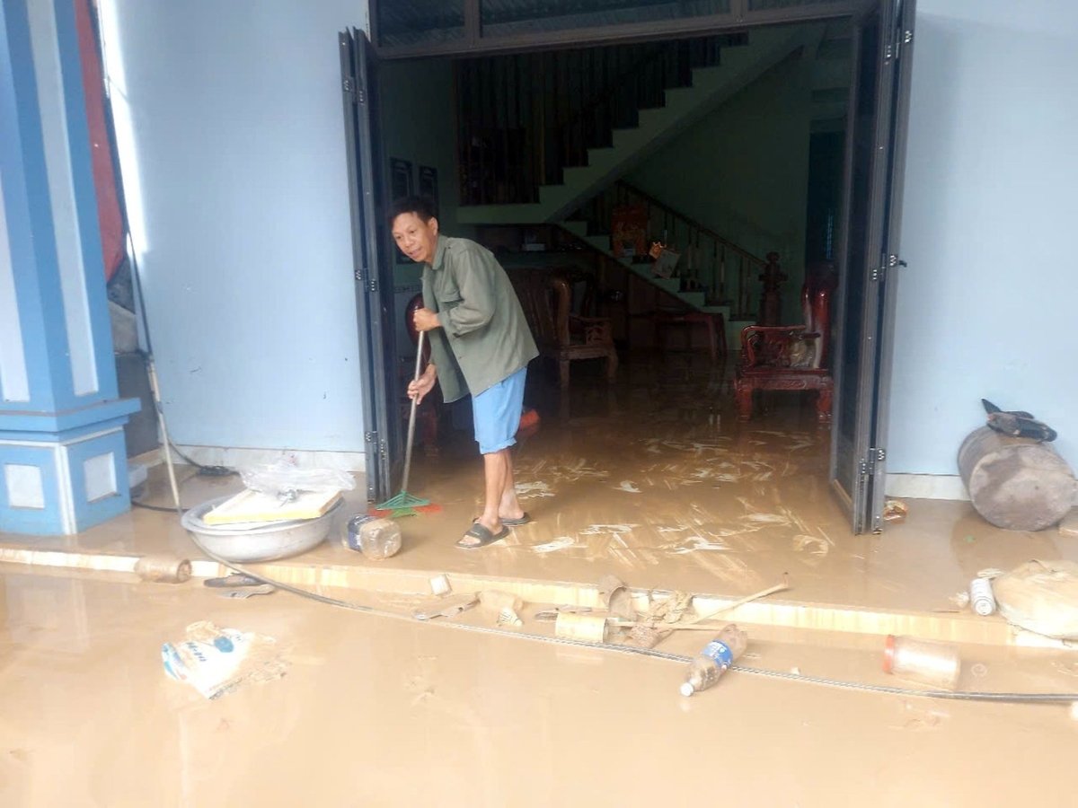 Các hộ dân ở thôn Vĩnh Hoàn, xã Con Cuông tranh thủ dọn dẹp bùn đất từ sáng sớm 24/7. Ảnh: Đình Tiệp.