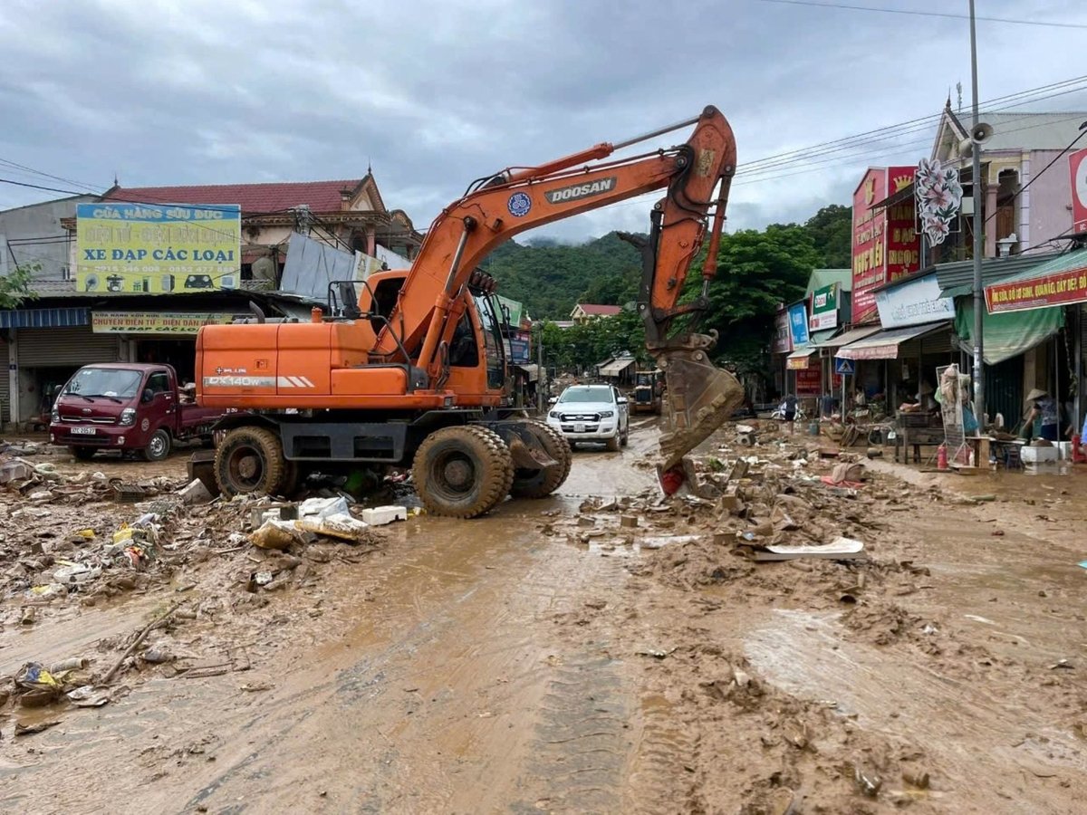 Máy xúc được huy động để dọn dẹp bùn đất dày đặc để khắc phục hậu quả lũ lụt. Ảnh: Đình Tuân.