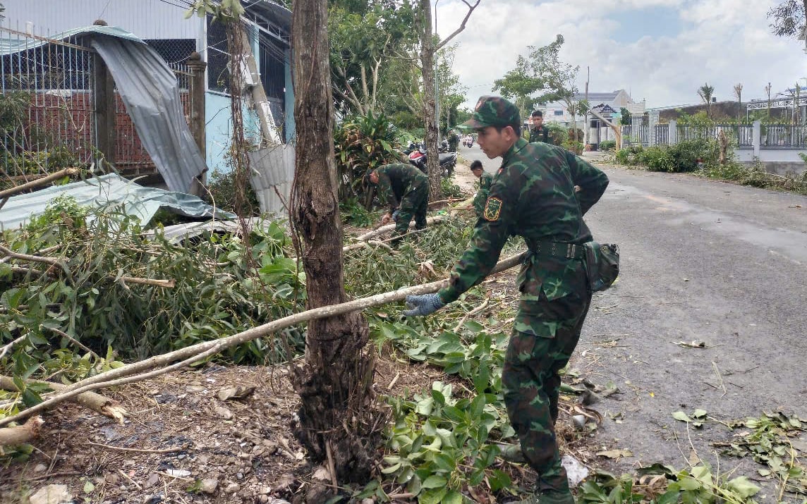 Người dân cùng lực lượng chức năng thu dọn cây đổ, sửa chữa nhà cửa bị tốc mái. Ảnh: CTV.