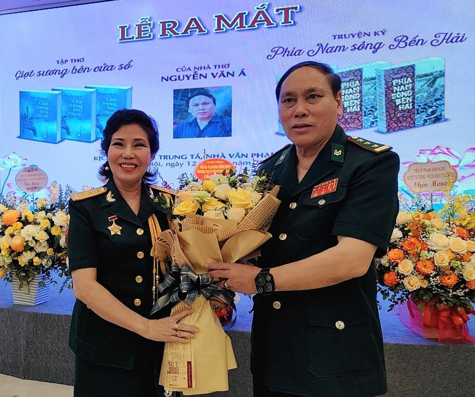 Đồng đội tặng hoa Thượng tá, nhà báo Nguyễn Văn Á trong lễ ra mắt sách. Ảnh: Ngô Đức Hành. Đồng đội tặng hoa Thượng tá, nhà báo Nguyễn Văn Á trong lễ ra mắt sách. Ảnh: Ngô Đức Hành.