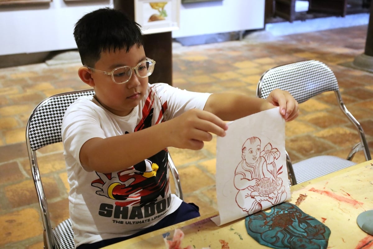 Khách tham quan trải nghiệm in tranh giấy dó. Ảnh: Hoàng Hiền. Khách tham quan trải nghiệm in tranh giấy dó. Ảnh: Hoàng Hiền.