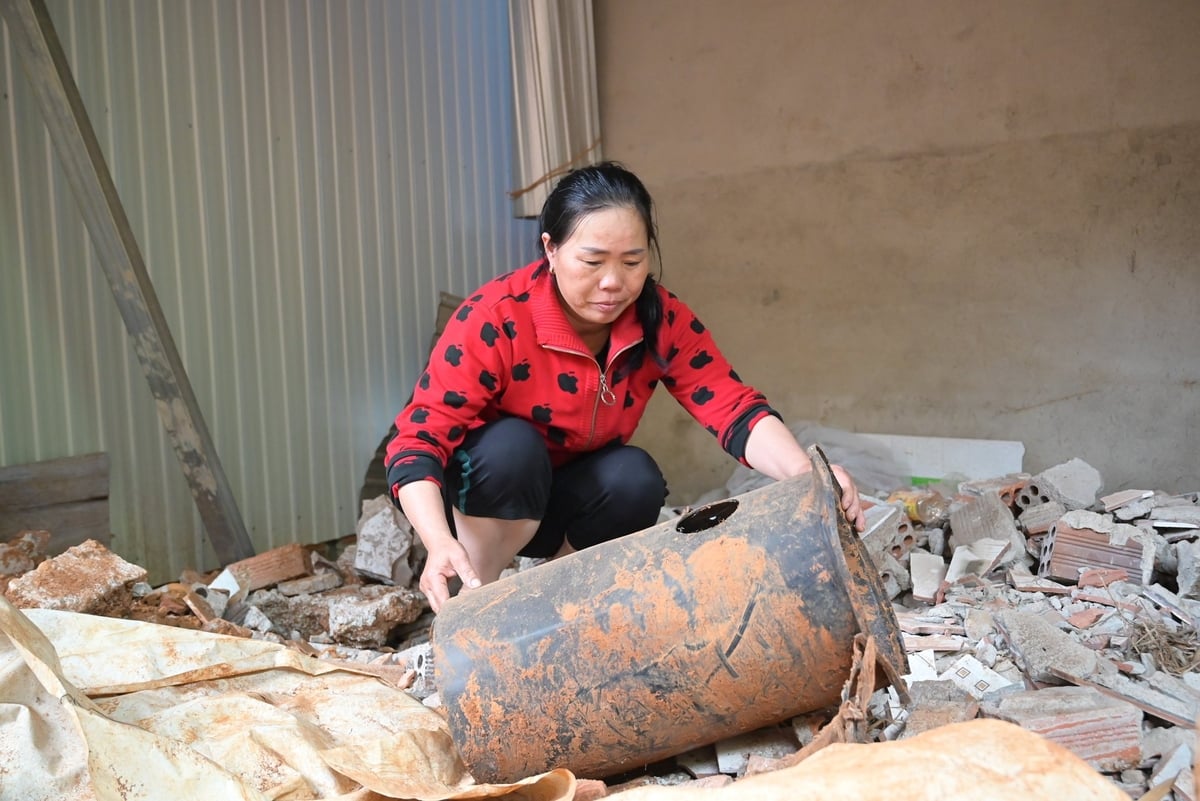 Chị Phan Thị Quyết, tổ dân phố 9, phường Bắc Gia Nghĩa gom dọn những phần còn lại khu vực phía sau ngôi nhà từng bị sạt lở. Ảnh: Phạm Hoài.