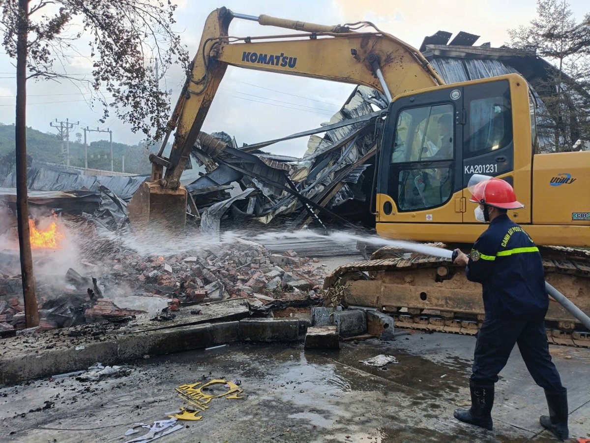Máy xúc được huy động đến hiện trường phá tường để hỗ trợ dập lửa. Ảnh: Thanh Tiến.