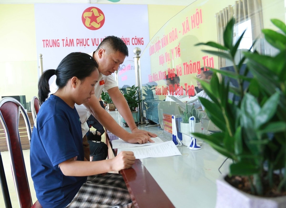 Anh Sùng A Bình, chuyên viên phụ trách văn hóa xã hội tại bộ phận hành chính công hướng dẫn chị Giàng Thị Sùng thực hiện thủ tục hành chính tại xã. Ảnh: Thanh Ngà. Anh Sùng A Bình, chuyên viên phụ trách văn hóa xã hội tại bộ phận hành chính công hướng dẫn chị Giàng Thị Sùng thực hiện thủ tục hành chính tại xã. Ảnh: Thanh Ngà.