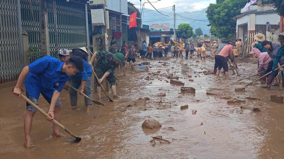 Đoàn viên thanh niên, các lực lượng và người dân dọn dẹp khi nước rút. Ảnh: Vũ Lợi. 