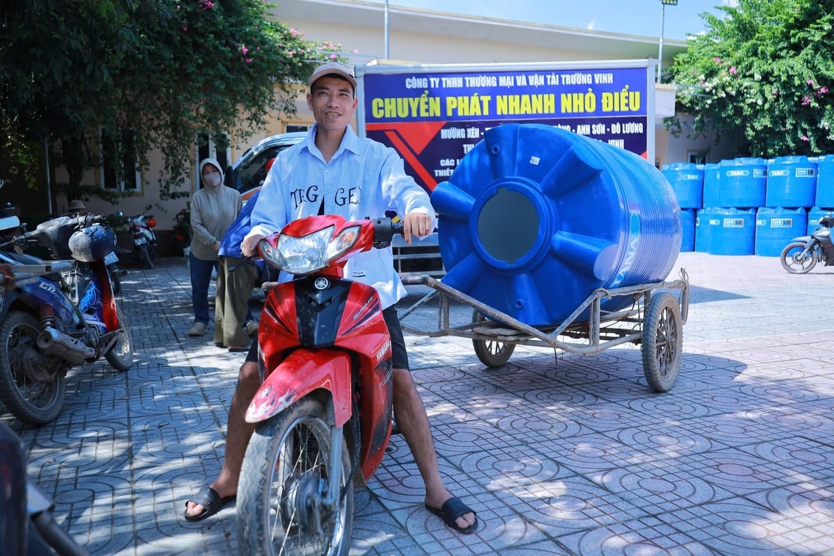 Người dân phấn khởi được trao tặng bồn chứa nước để sớm có nước sạch sử dụng. Ảnh: Ngọc Linh.