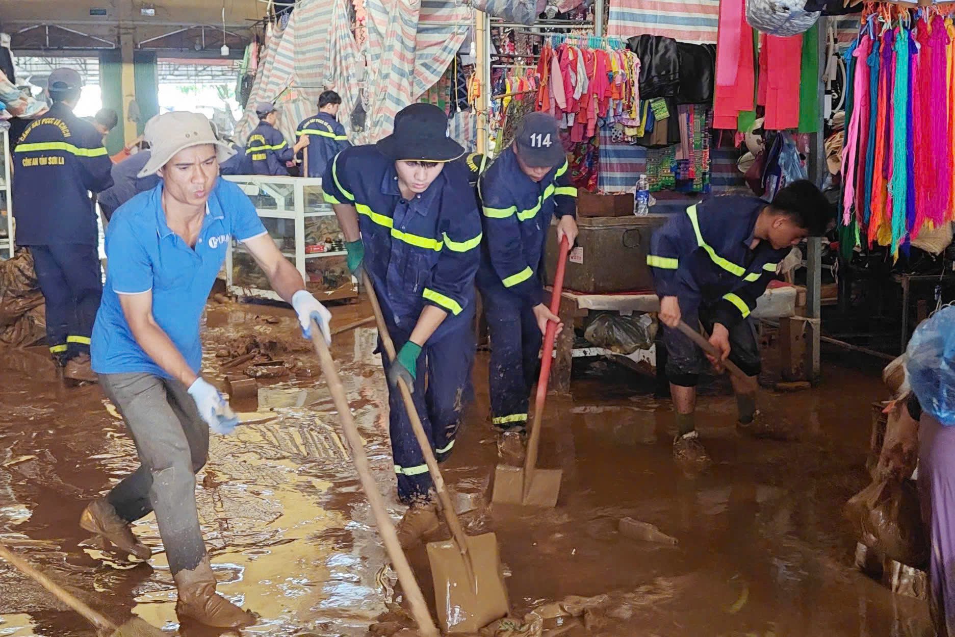 Cán bộ, chiến sĩ Phòng Cảnh sát PCCC và CNCH, Công an tỉnh hỗ trợ tiểu thương chợ Sông Mã dọn dẹp bùn đất. Ảnh: Đức Bình. Cán bộ, chiến sĩ Phòng Cảnh sát PCCC và CNCH, Công an tỉnh hỗ trợ tiểu thương chợ Sông Mã dọn dẹp bùn đất. Ảnh: Đức Bình.