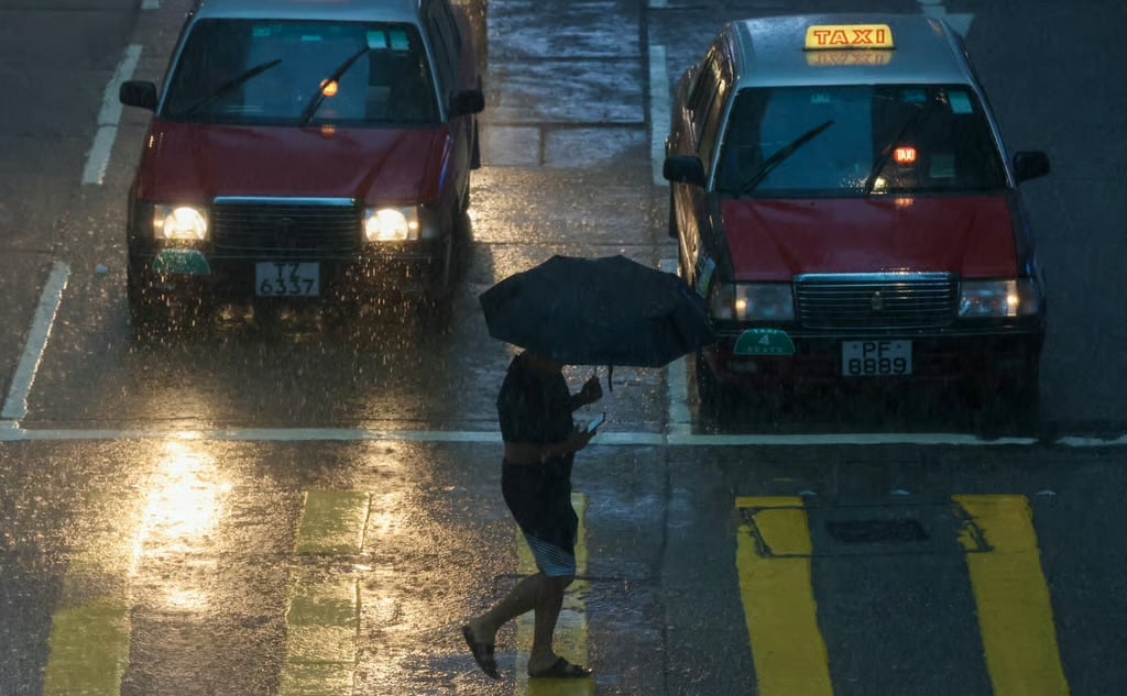 Một người dân băng qua đường khi 'mưa đen' đang đổ bộ tại Hong Kong. Ảnh: Jonathan Wong. Một người dân băng qua đường khi 'mưa đen' đang đổ bộ tại Hong Kong. Ảnh: Jonathan Wong.