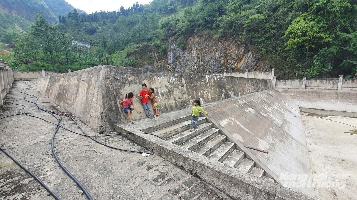 Children play by a hanging reservoir in Lung Cam hamlet, recently cleaned to prepare for water storage during the rainy season. Photo: Kien Trung.