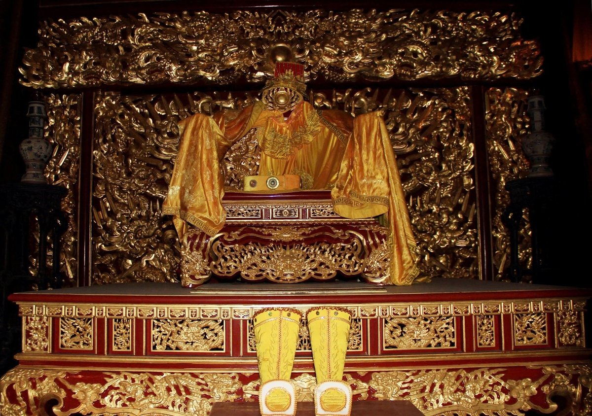 Ngai vàng của Vua với 'long bào', 'long ngai' và 'long hài', tại điện Sùng Hiếu. Sau ngai vàng là bức phù điêu 'cửu long quần tụ'. Ảnh: Thanh Tâm Ngai vàng của Vua với 'long bào', 'long ngai' và 'long hài', tại điện Sùng Hiếu. Sau ngai vàng là bức phù điêu 'cửu long quần tụ'. Ảnh: Thanh Tâm