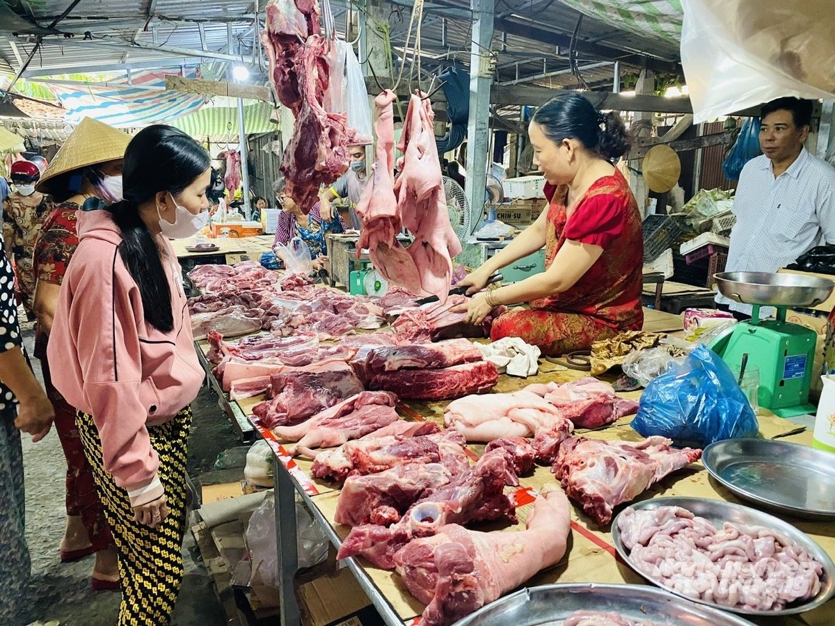 Người tiêu dùng lựa chọn thịt heo tại chợ truyền thống, việc kiểm soát nguồn gốc thịt và vệ sinh an toàn thực phẩm là yếu tố quan trọng để bảo vệ sức khỏe cộng đồng. Ảnh: Lê Hoàng Vũ.