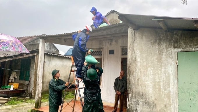 Military forces assist local residents in reinforcing corrugated iron roofs as a preparedness measure before the typhoon makes landfall. Photo: VAN.