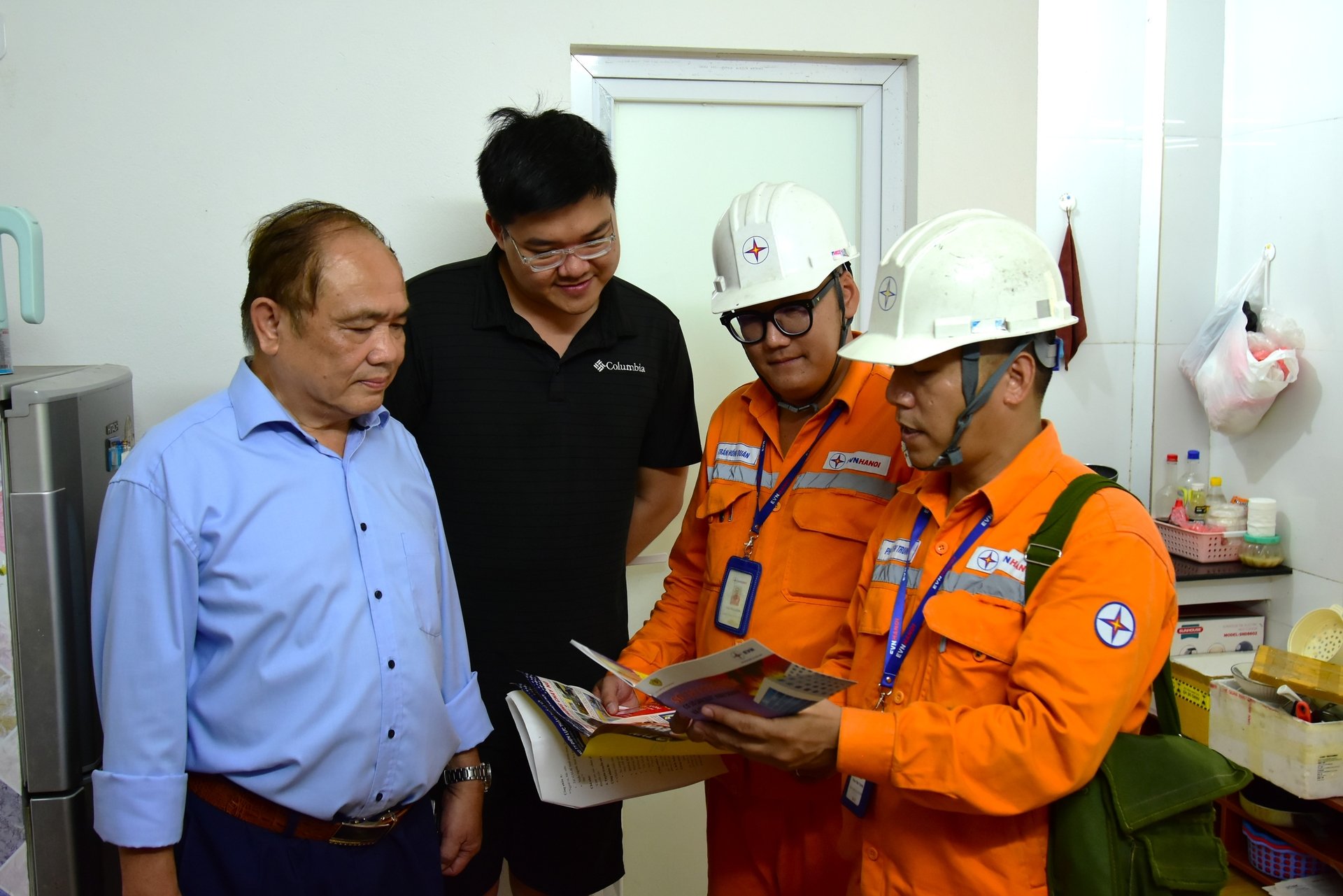 Công nhân EVNHANOI phối hợp với tổ dân phố tuyên truyên an toàn điện, phòng chống cháy nổ tại nhà trọ thuộc phường Hà Đông. Ảnh: EVNHANOI.