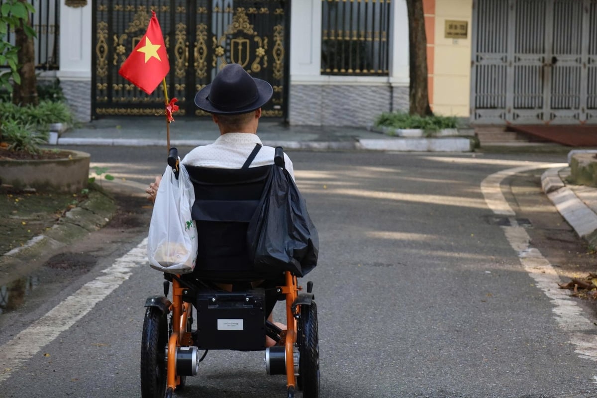 Lá cờ Tổ quốc được cắm trên chiếc xe lăn. Ảnh: Hoàng Hiền.