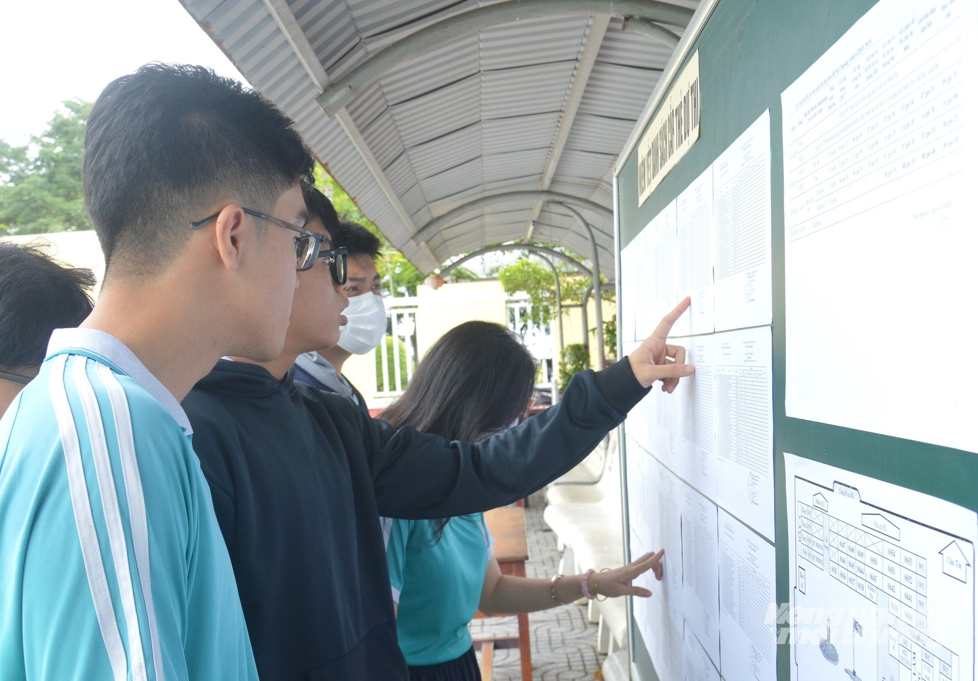 Học sinh trường THCS và THPT Võ Văn Kiệt (phường Rạch Giá) dò tìm danh sách và sơ đồ bố trí lớp học tại bảng thông tin của trường. Ảnh: Trung Chánh.