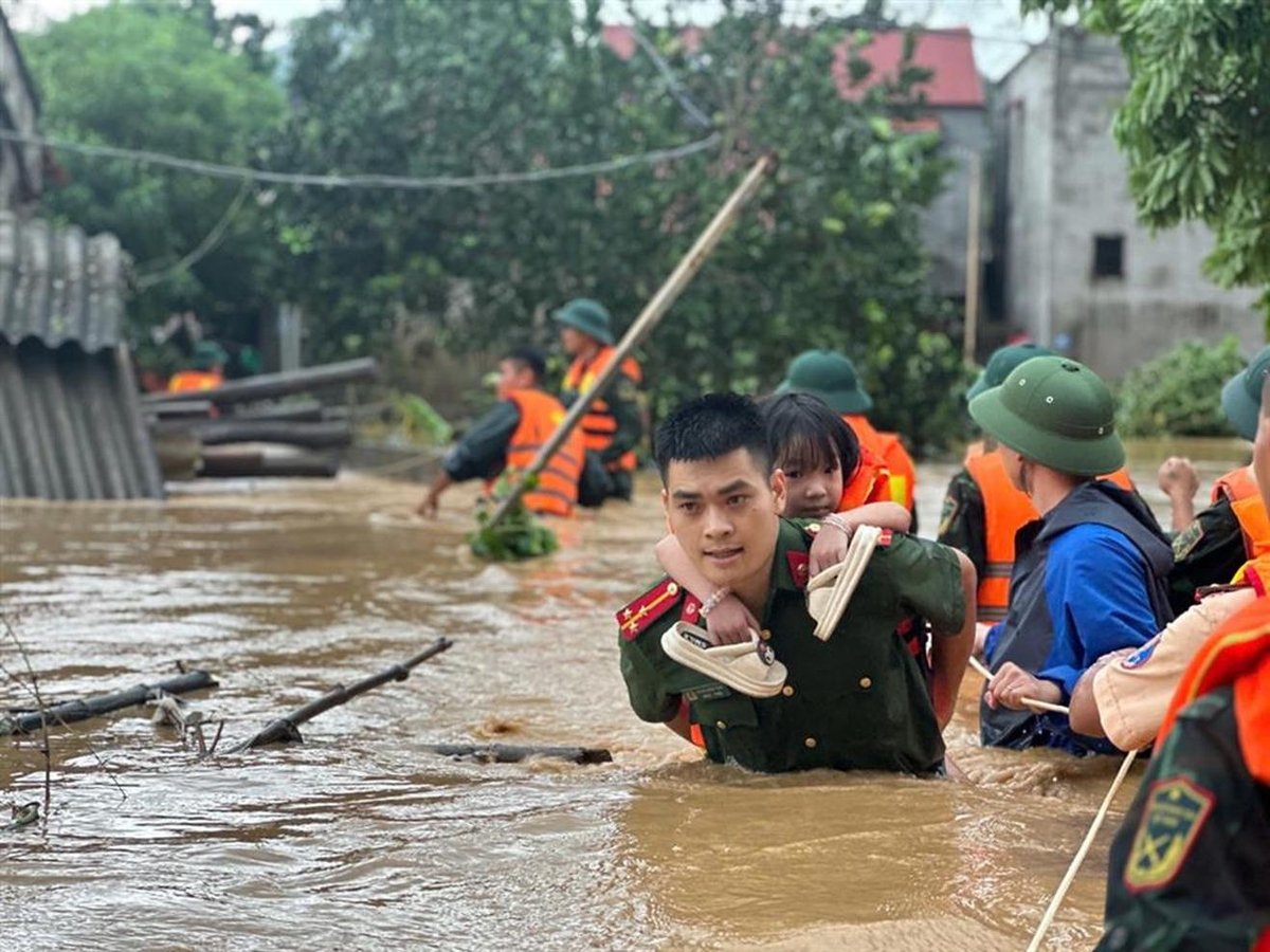 Các chiến sĩ công an hỗ trợ người dân xuyên ngày, trắng đêm di chuyển người và tài sản đến vùng an toàn. Ảnh: VGP