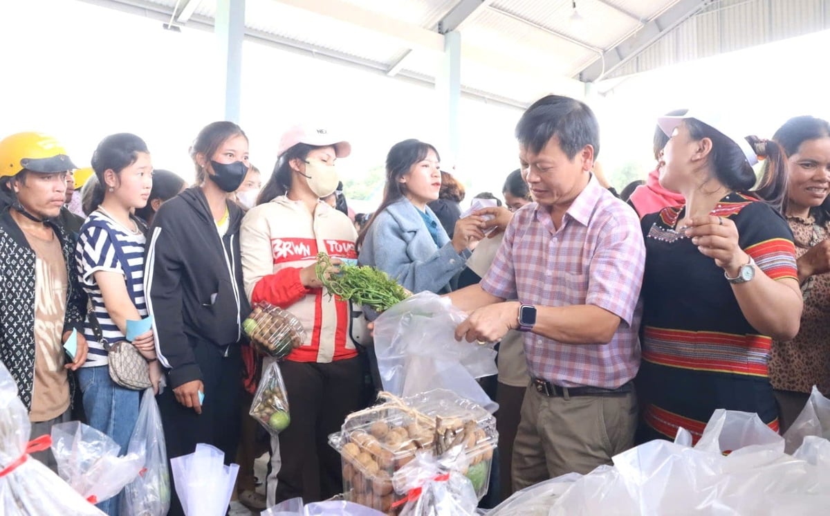 Chủ tịch UBND xã Tu Mơ Rông Trần Quốc Huy (áo caro) trao những sản phẩm 0 đồng cho người dân. Ảnh: Tuấn Anh.